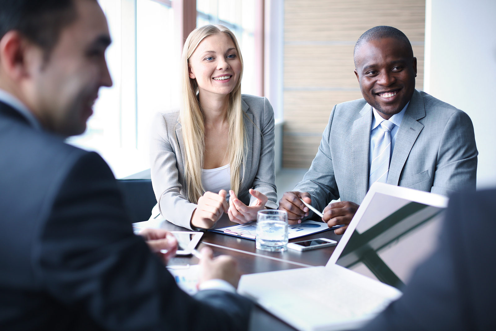 Image of business people listening and talking to their colleague at meeting